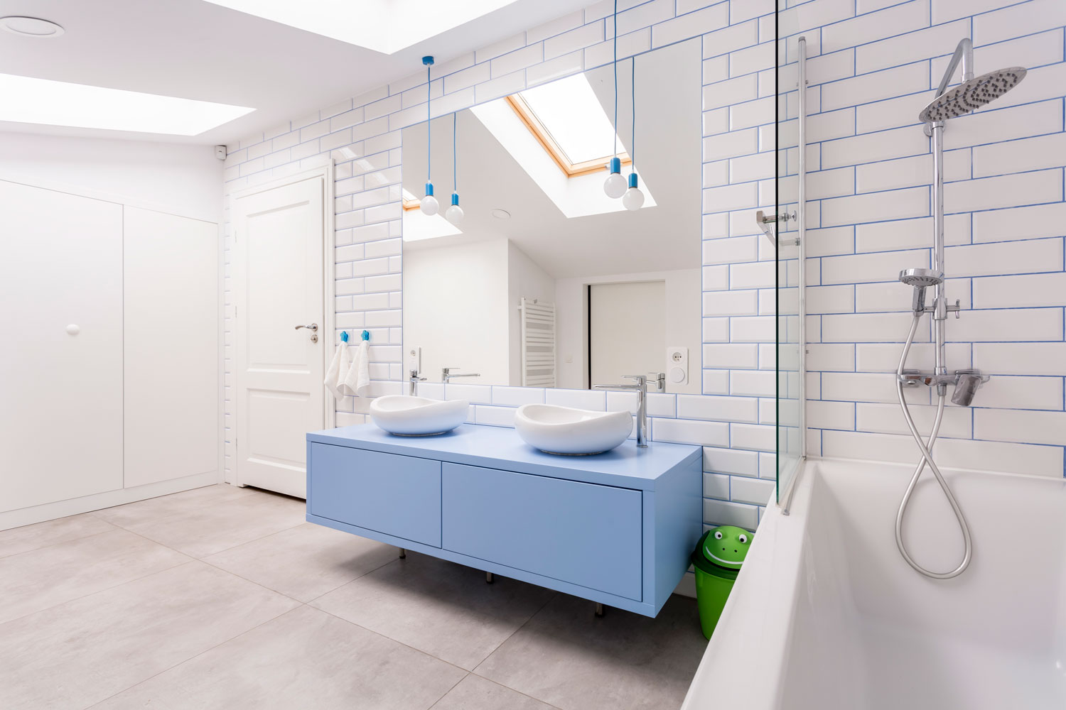 Huge and spacious bright blue and white themed bathroom with a skylight window