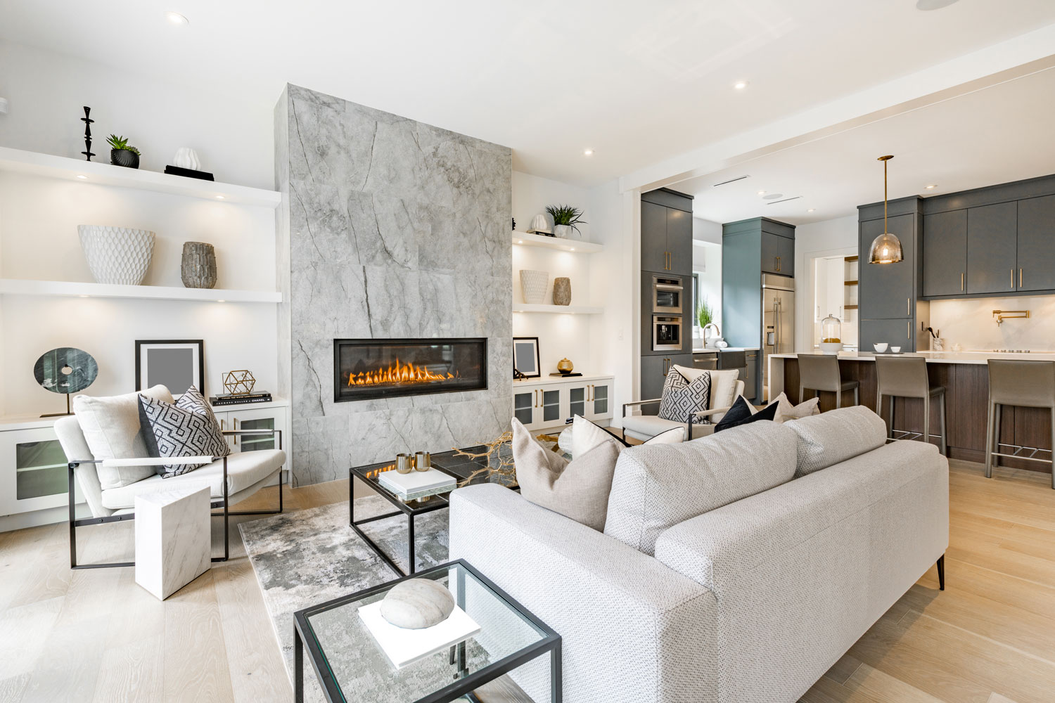 Luxurious modern white living room with a gas fireplace, white sofas and skeletal metal tables and chairs
