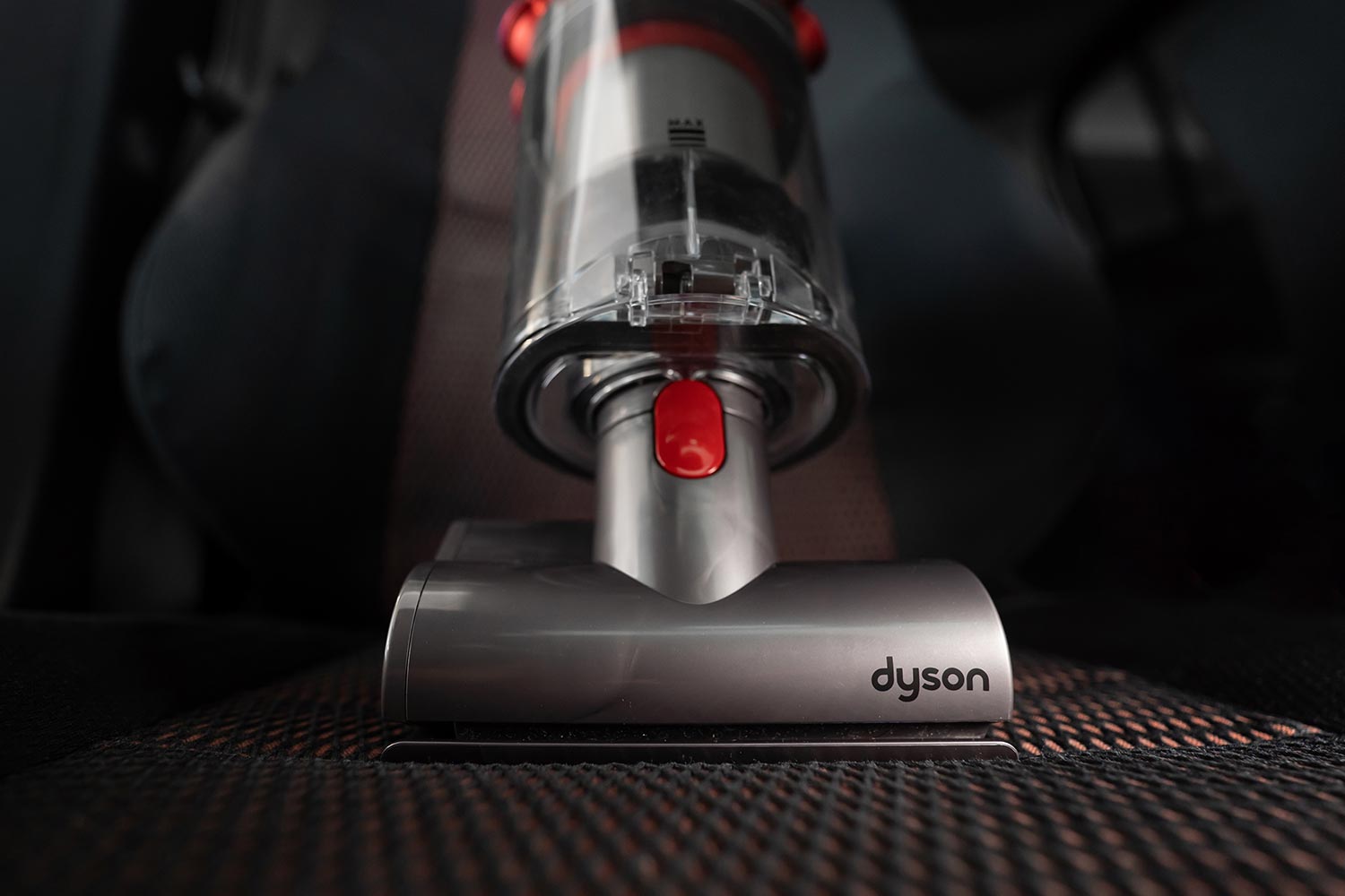 Mini motorhead of Dyson Cyclone V10 Fluffy vacuum cleaner on car seats