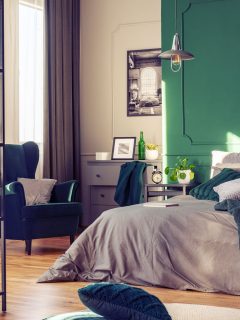Minimalist bedroom with green accent walls and green and gray beddings with plants for vibrancy, 15 Colorful Bedroom Walls Ideas You Need To See