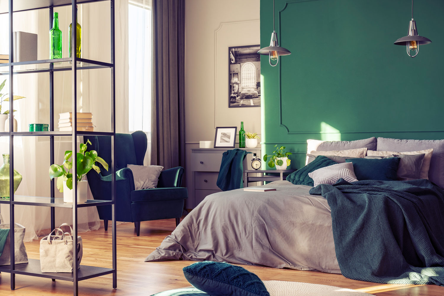 Minimalist bedroom with green accent walls and green and gray beddings with plants for vibrancy