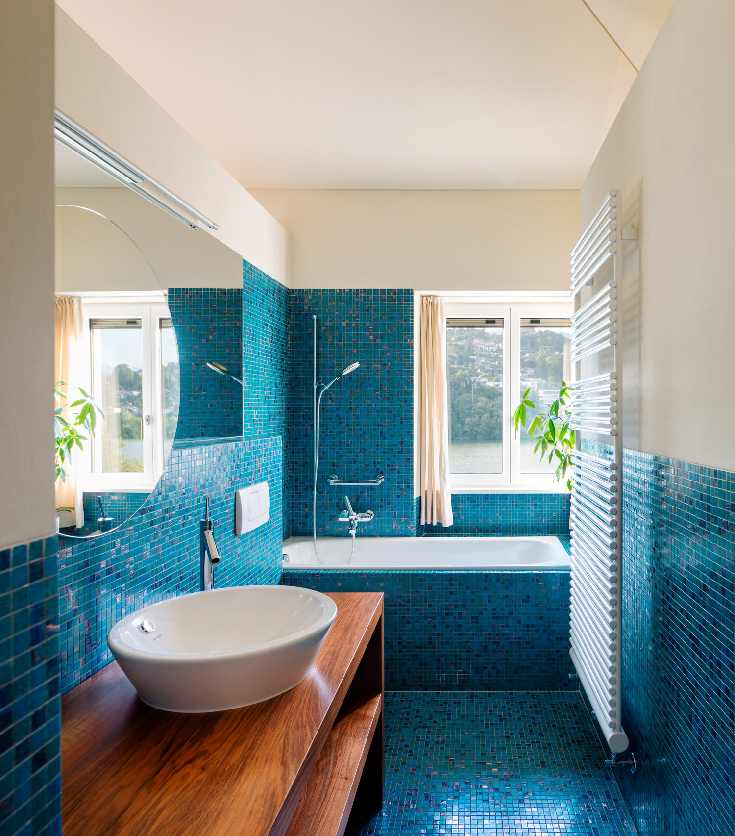 Modern blue bathroom interior, overlooking nature. No one inside is very empty. Warm light