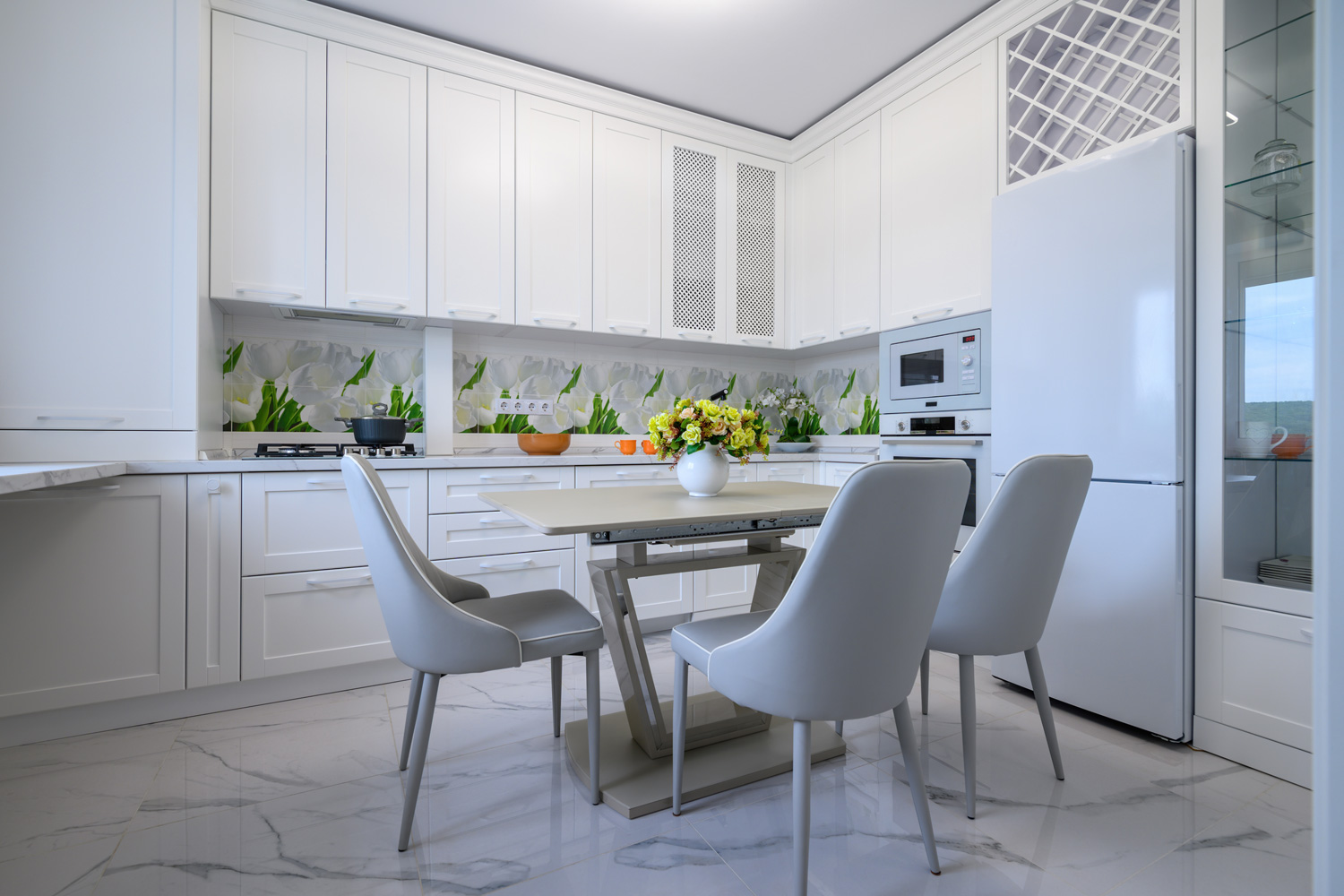Modern compact white colored luxurious kitchen interior with dining table