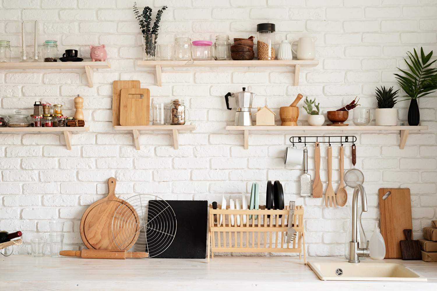 Rustic kitchen interior with brick wall and white wooden shelves, front view