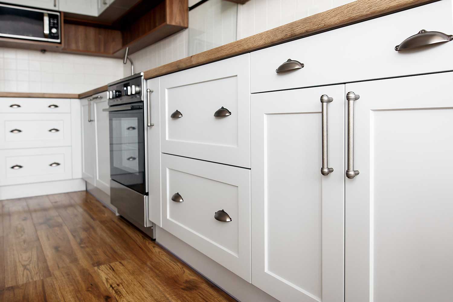 Stylish light gray handles on cabinets close-up