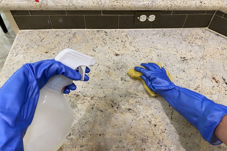 Using anti bacterial cleaning spray to sterilize counter tops to prevent infection - How to Fix Dull Spots on Quartz or Granite Countertops