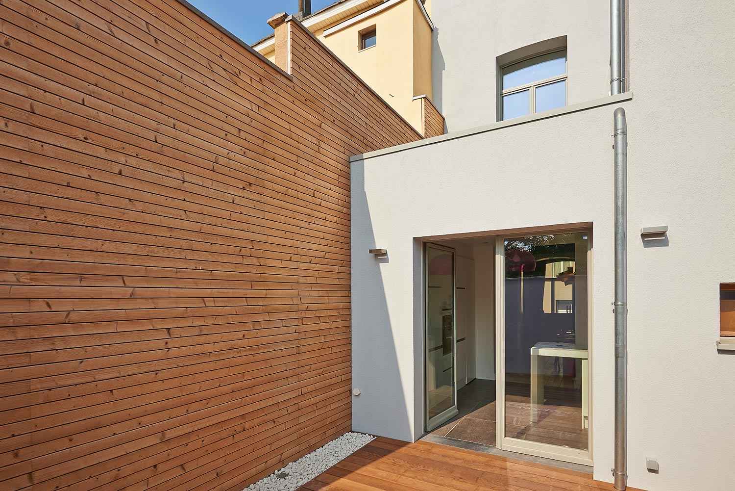 Wall construction with insulating wood cladding in countryard