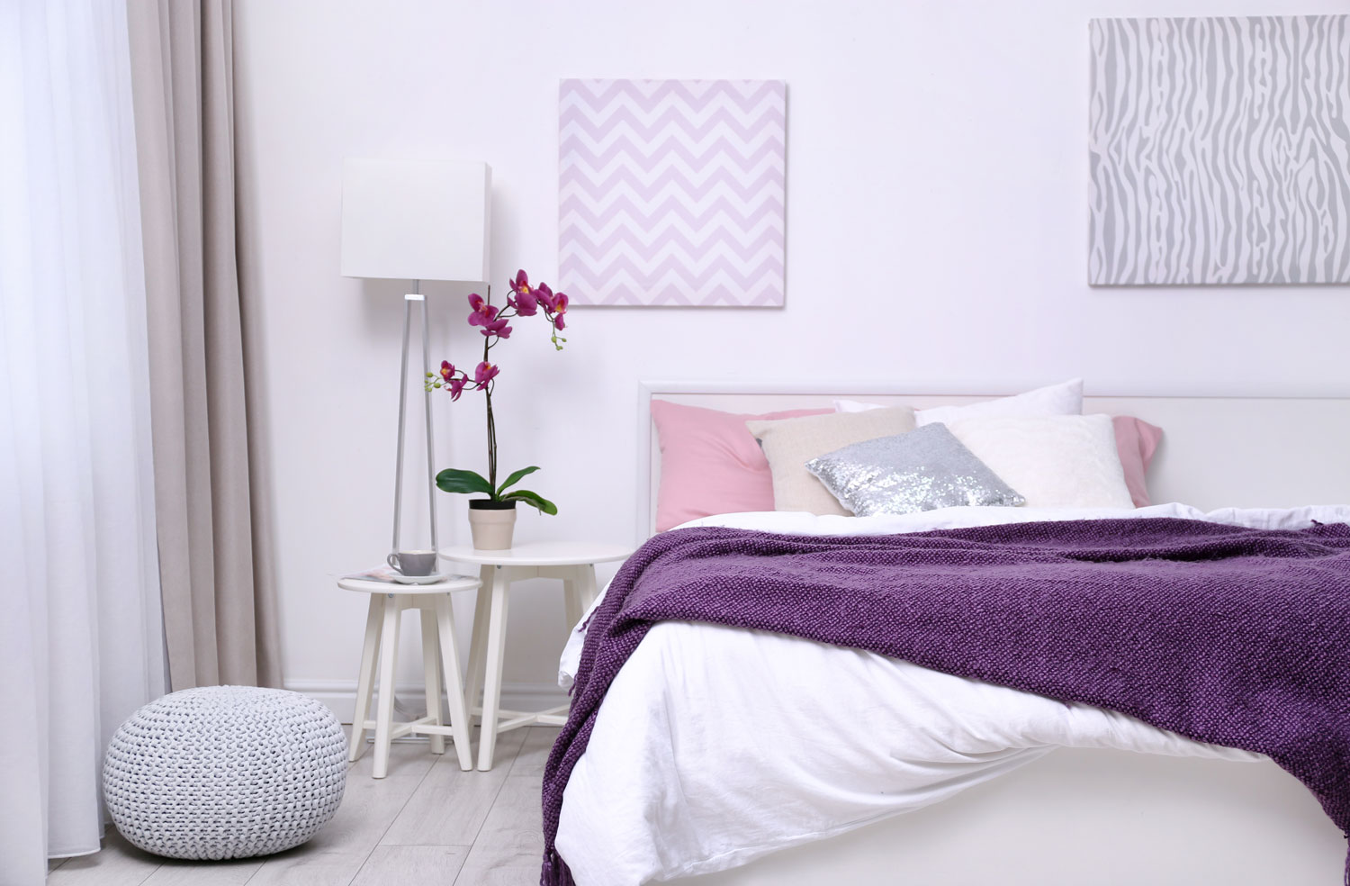 White and modern bedroom with white painted walls matched with lavender beddings and a chair nightstand with a lampshade
