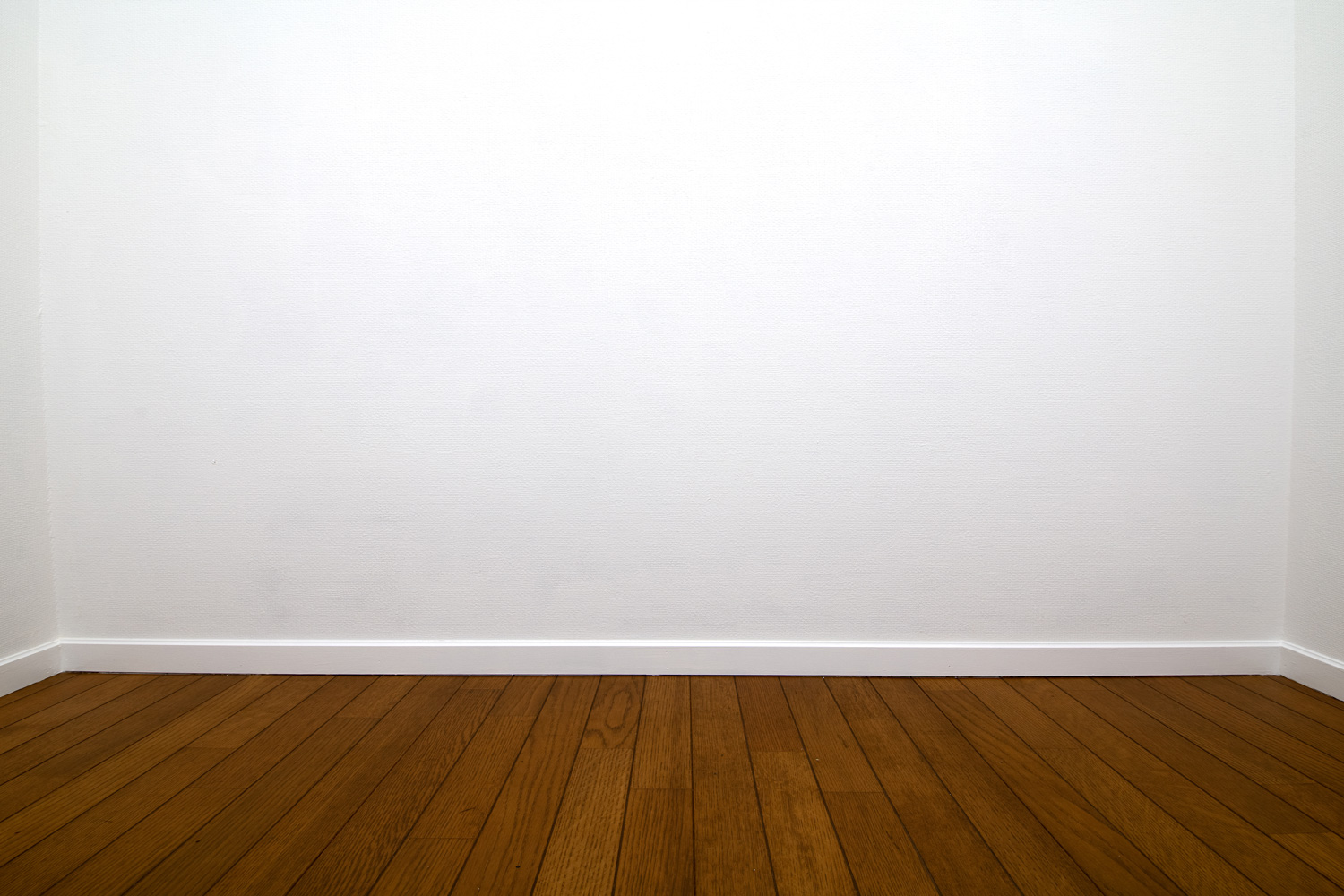 White room. Three walls of a white room with wood flooring and white trims.