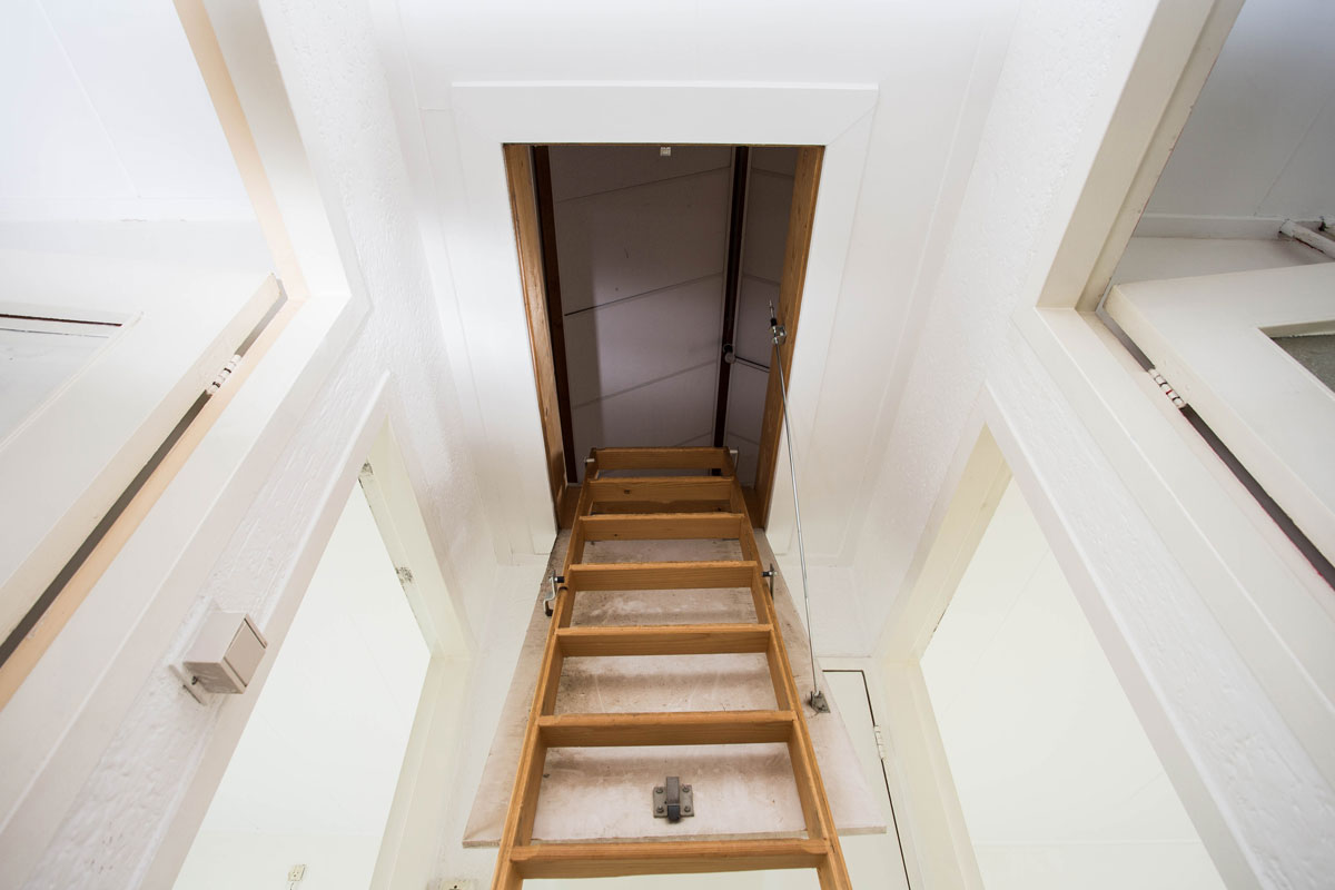 Wooden staircase to the attic in a modern house