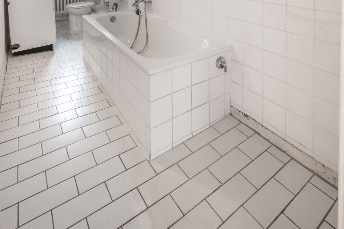 old white tiled bathroom with bathtub