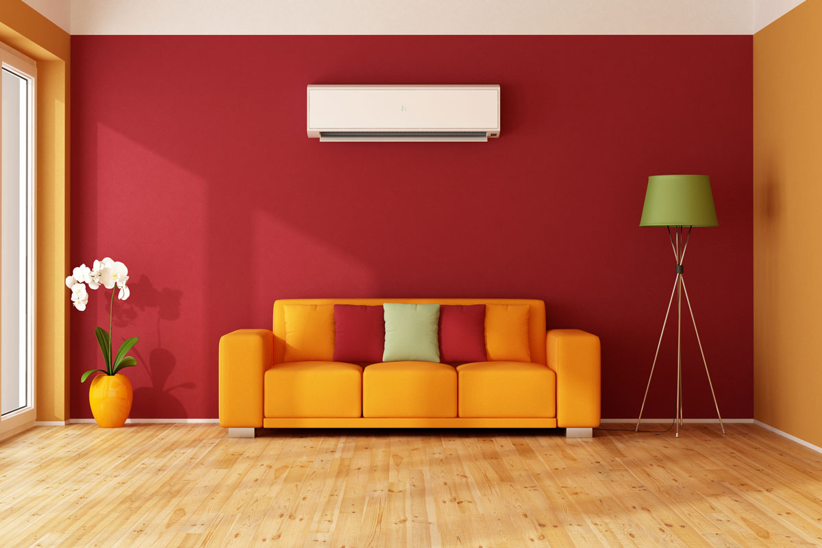 Red and orange living room with colorful sofa and air conditioner