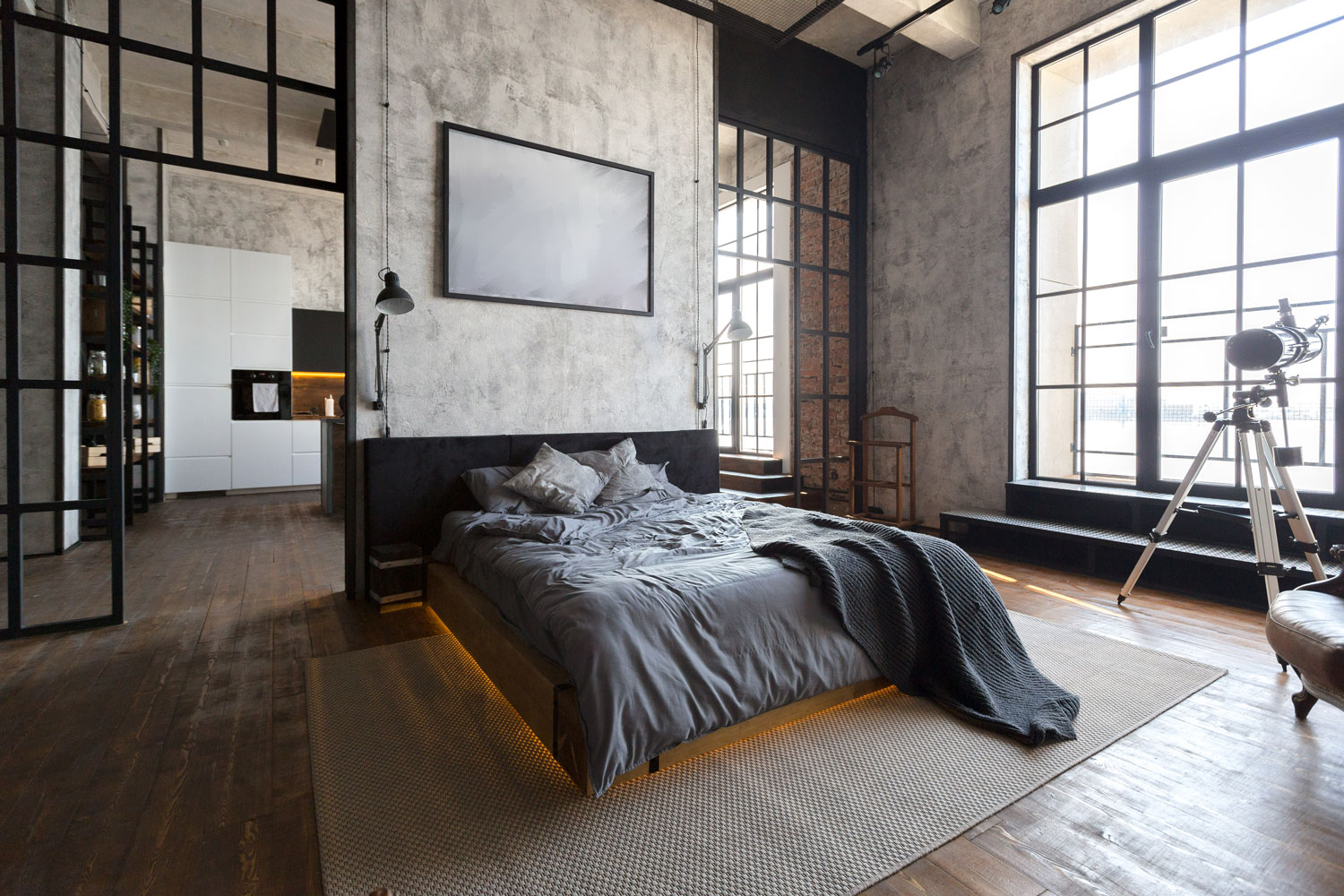 A huge open space bedroom with gray beddings on the bed with orange backlight