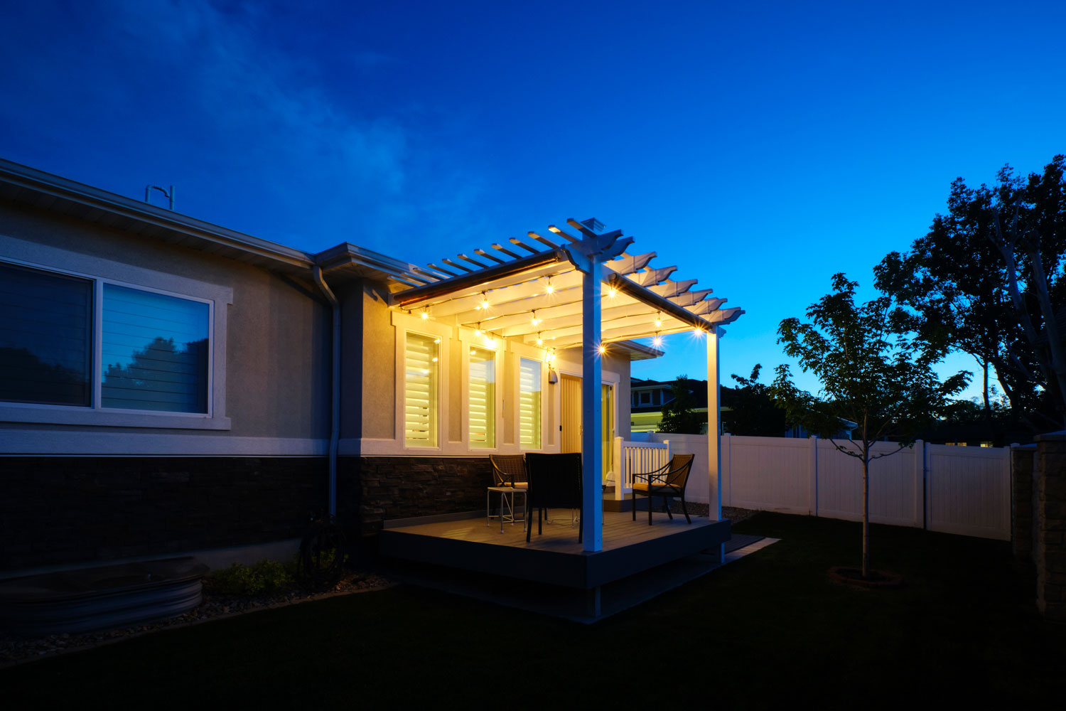 A porch with gorgeous trellis and ceiling lights left turned on