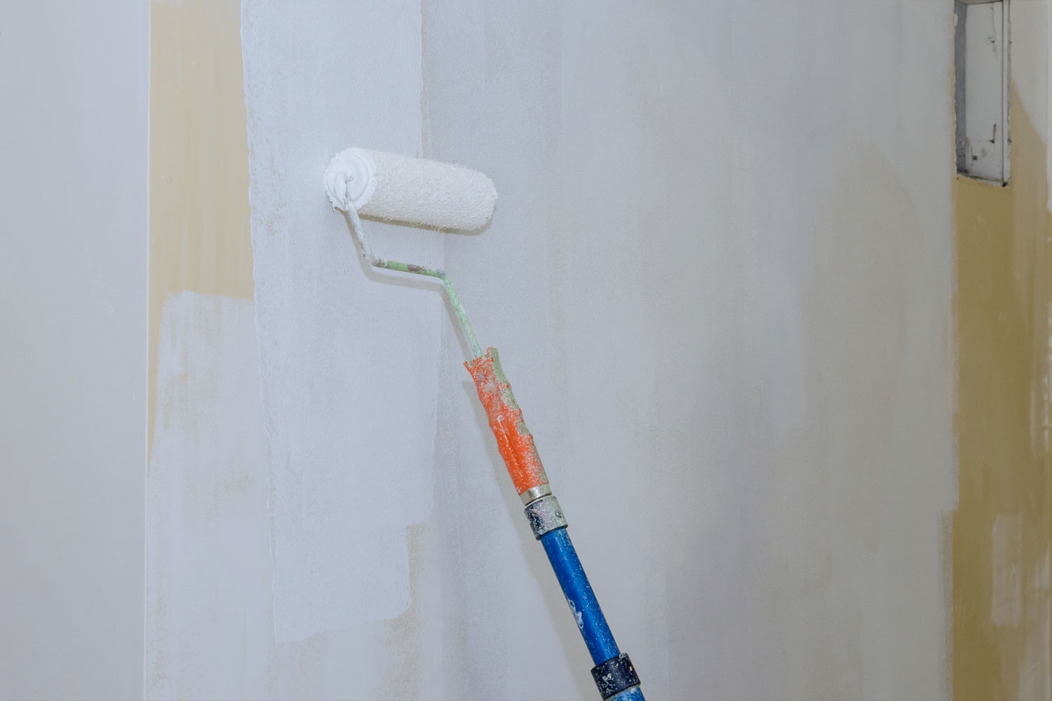 Applying white paint on the walls