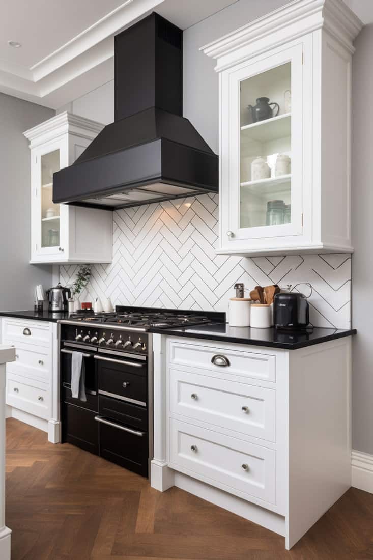 kitchen showcasing black worktops paired with white cabinets. Black dramatic hood above an oven, with a herringbone backsplash