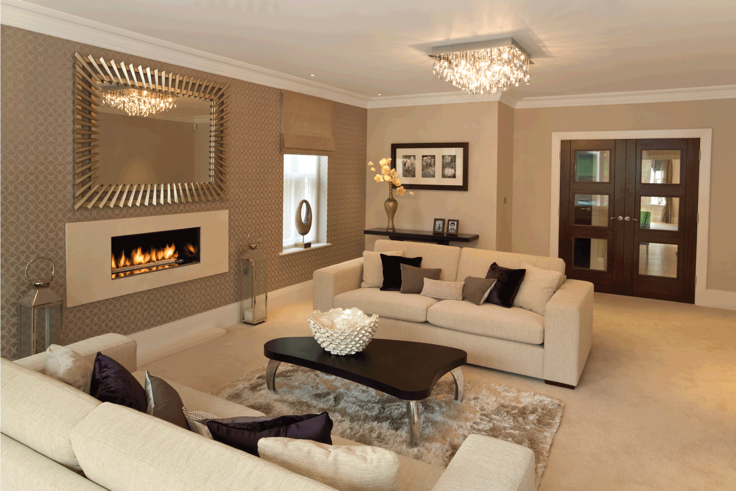 Chocolate Beige Living Room with Two large settees covered with silk cushions sit alongside a beautiful modern gas fireplace