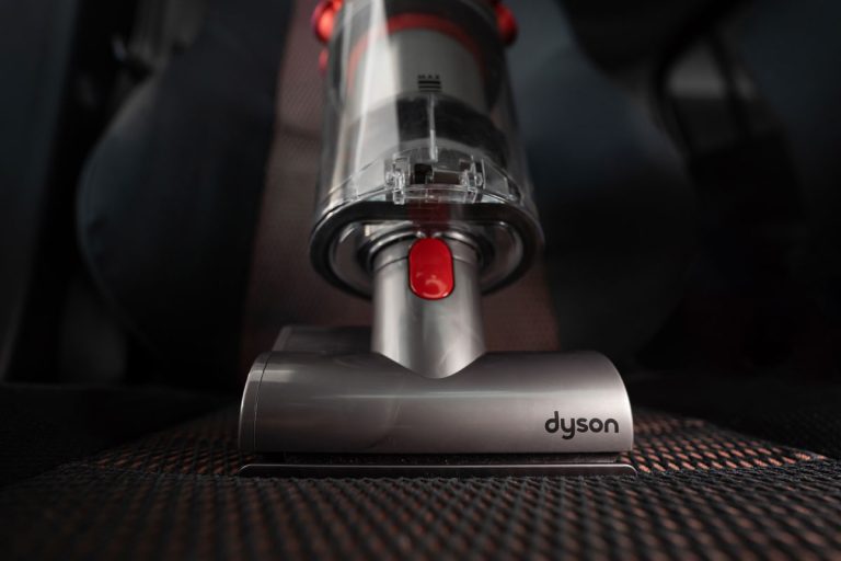 Close up of the Mini motorhead of Dyson Cyclone V10 Fluffy vacuum cleaner on car seats with car interior background, Dyson Starts Then Stops—What To Do?