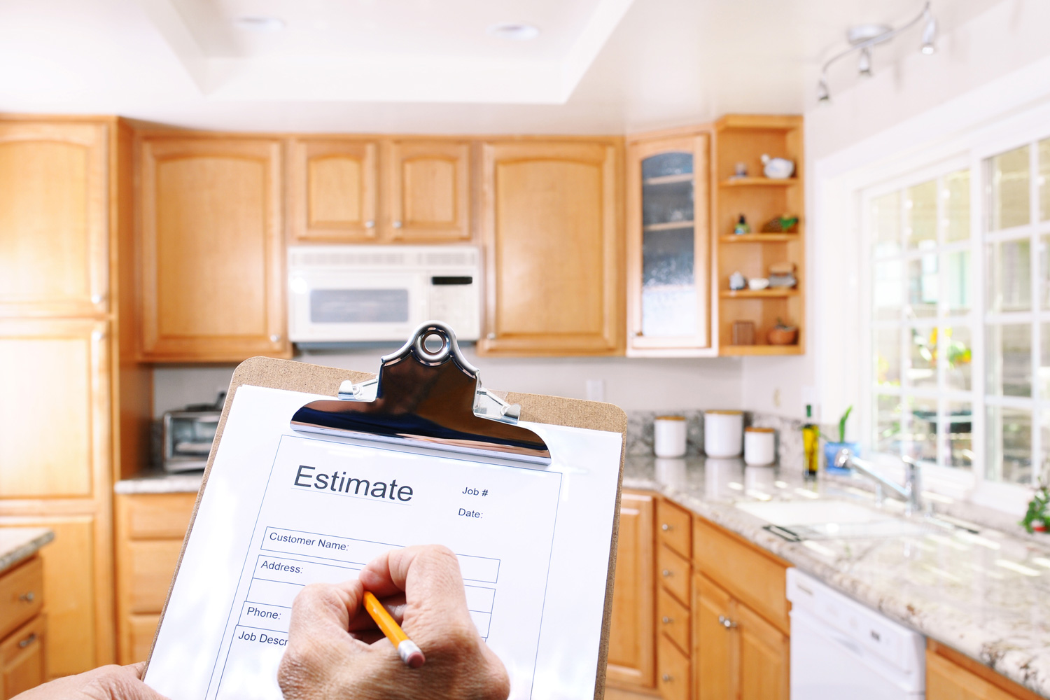 Closeup of a contractors clipboard as he writes up an estimate for a kitchen remodel. Shallow depth of field with focus on clipboard.