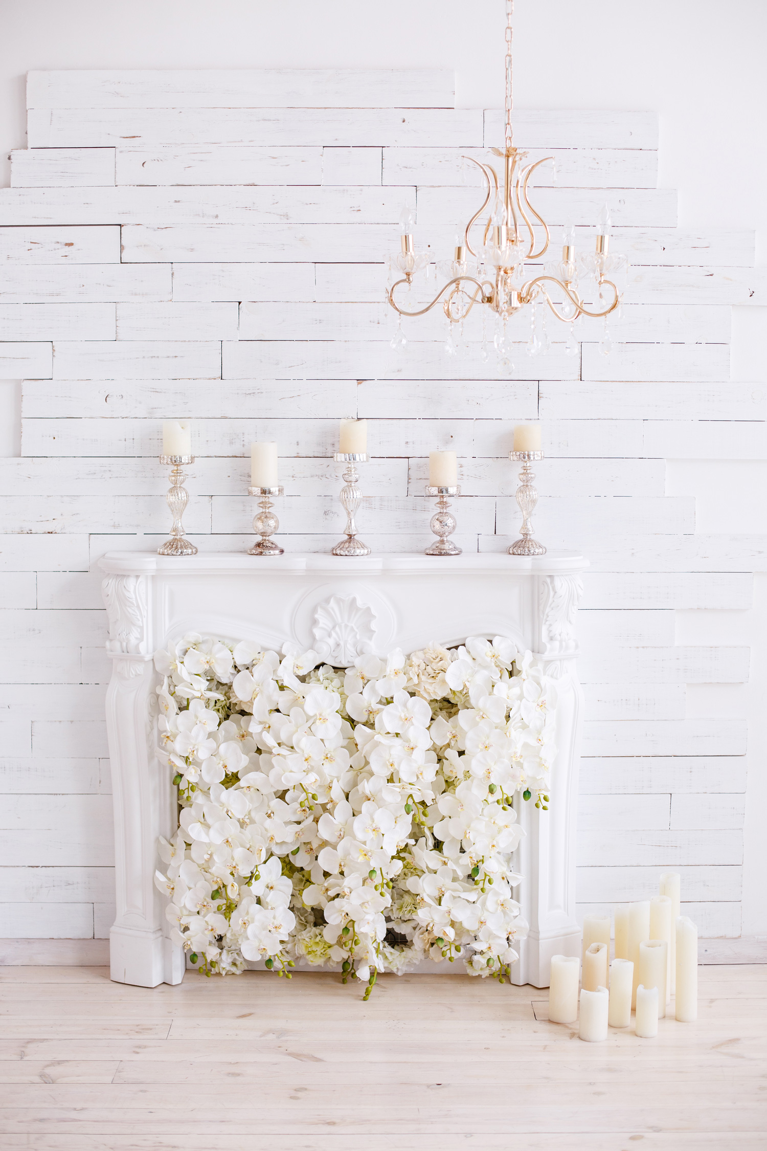 Elegant white fireplace full of flowers instead of fire. Elegant room
