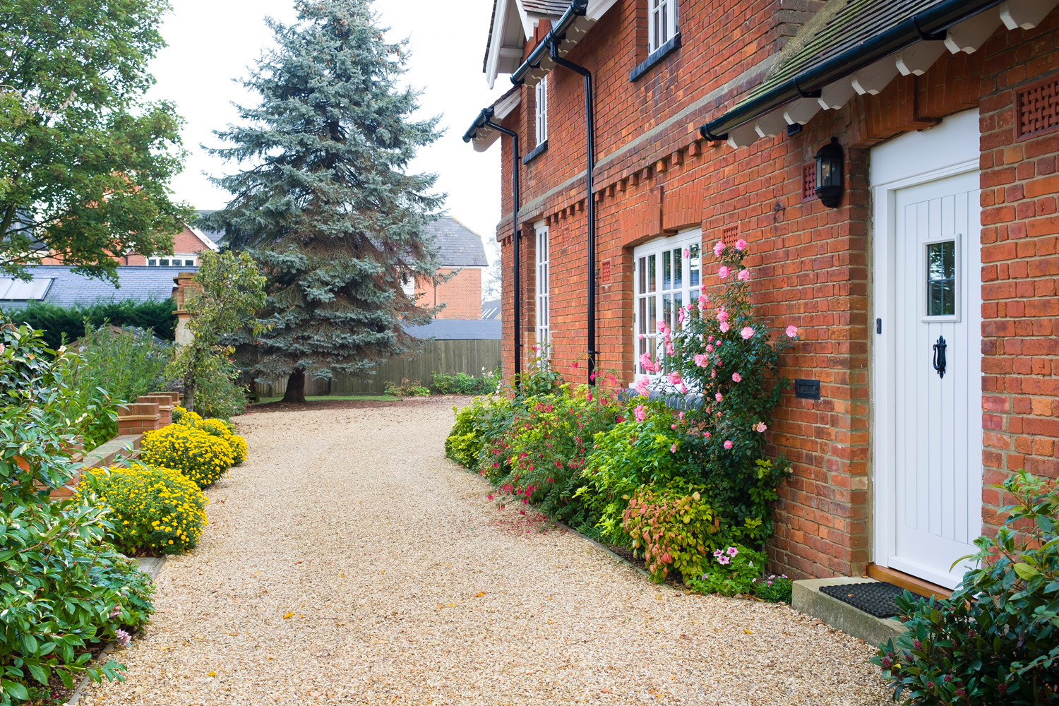 English country house and garden in Autumn with a gravel driveway.