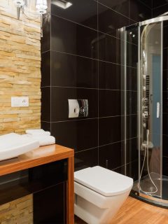 An extravagant decor of new bathroom with black tiles, Where To Stop Tile In The Shower [And Which Kind To Use]