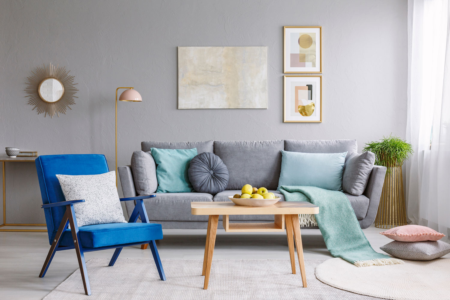 Gray living room wall with gray sofa and bright pillows