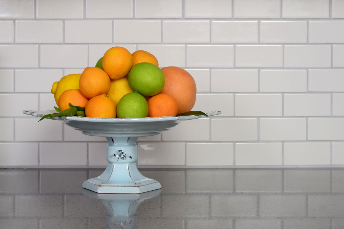 Homegrown selection of citrus fruit in retro modern kitchen with white ceramic subway
