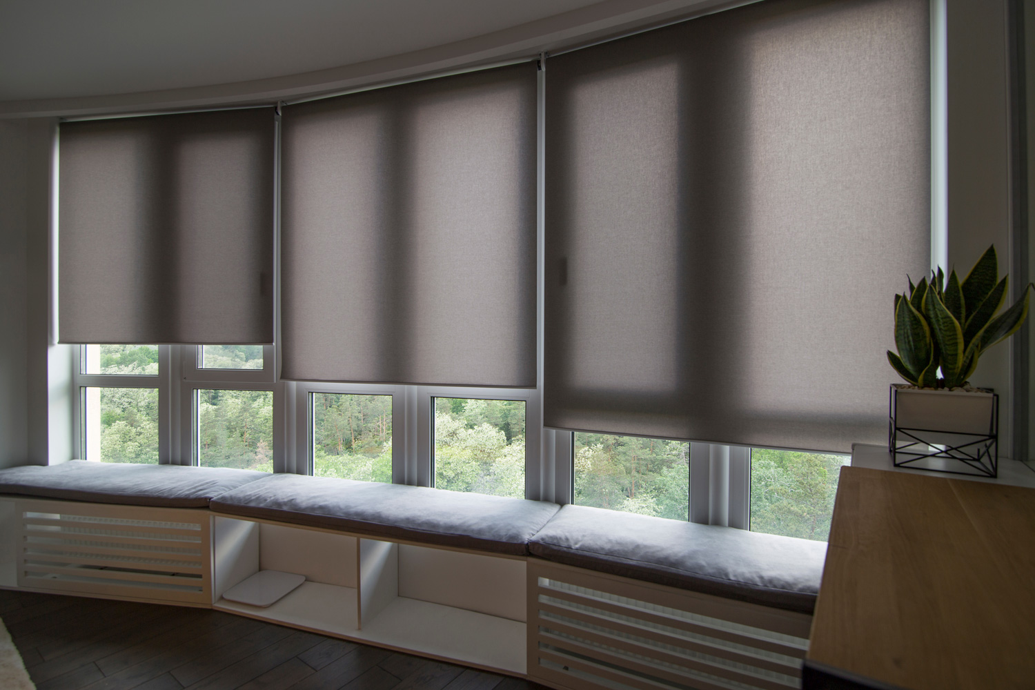 Motorized roller shades in the interior. Automatic roller blinds beige color on big glass windows.