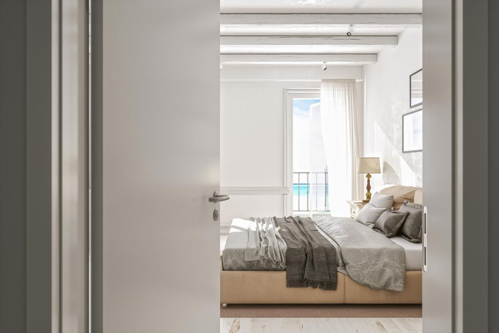 Open door to an empty modern bedroom with ocean view