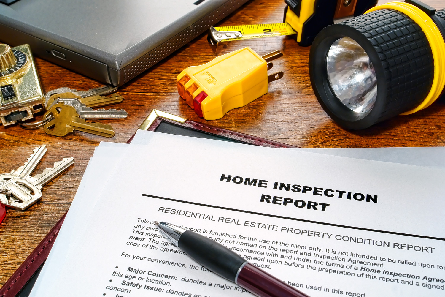 Real estate home inspection report of resale residential property condition with professional housing engineering inspector testing tools and house keys