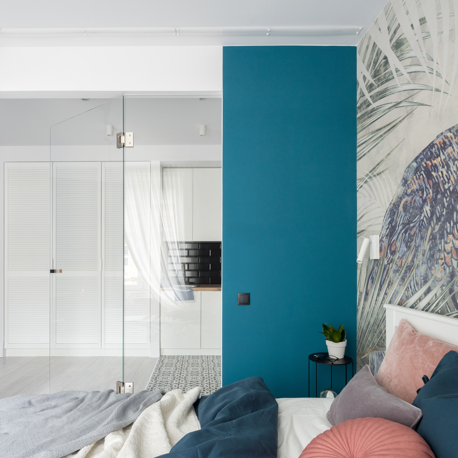 Stylish and chic bedroom with glass doors and decorative blue wall and nice wallpaper behind bed