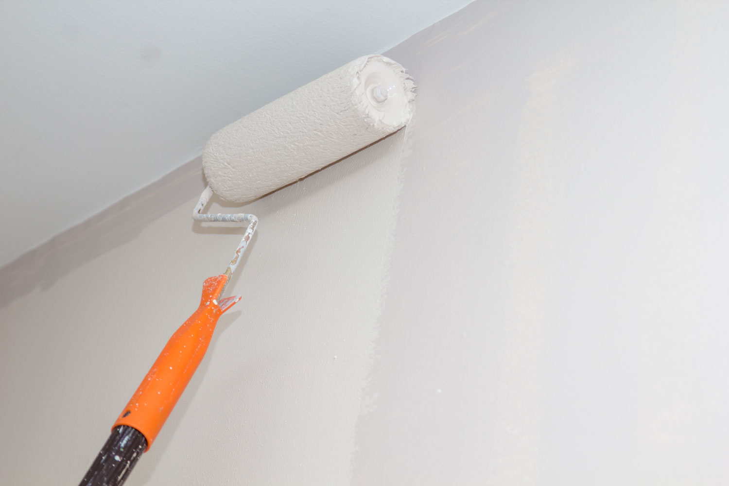 Using a roller to apply white paint