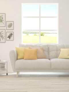 White living room with sofa and summer landscape in window, How To Get Febreze Smell Out Of Couch?