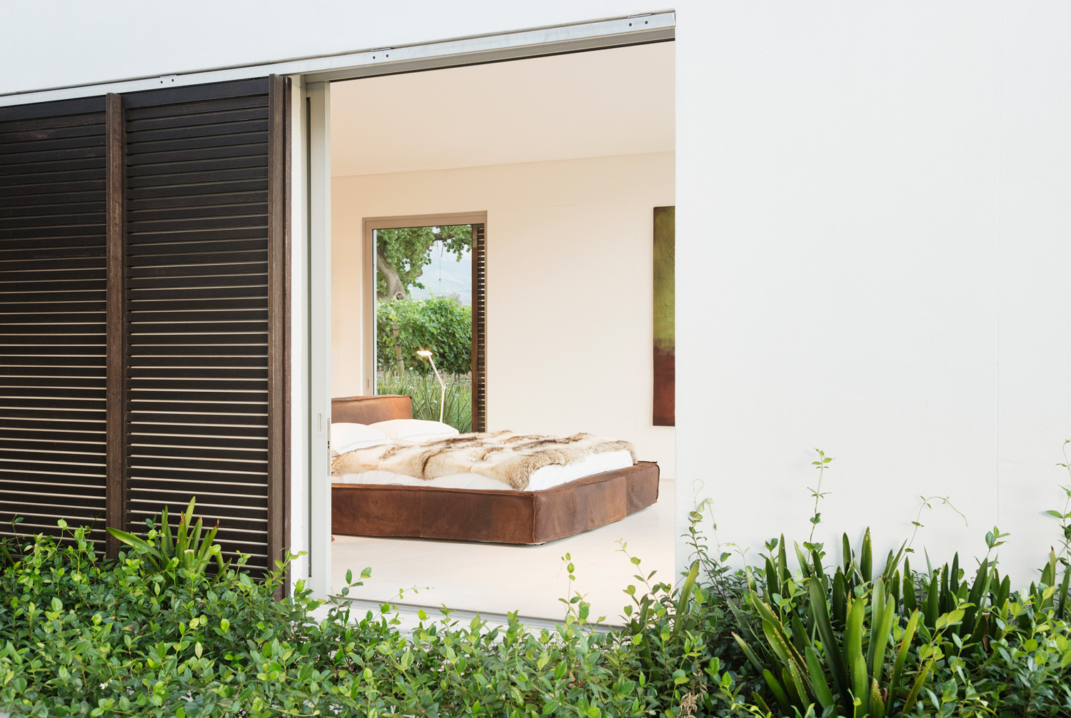 Wood shutters and sliding door to modern bedroom