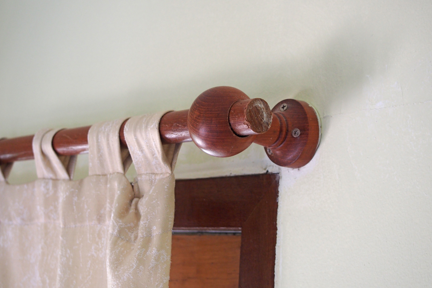 brown wooden curtain rail on concrete wall