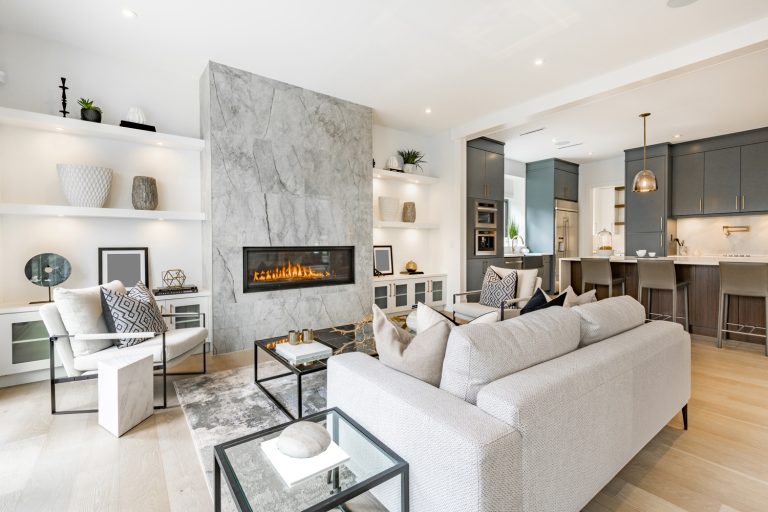 contemporary living room with open concept view through to dining room kitchen and a marble fireplace with gas fire - How To Decorate A Living Room With A Fireplace In The Middle
