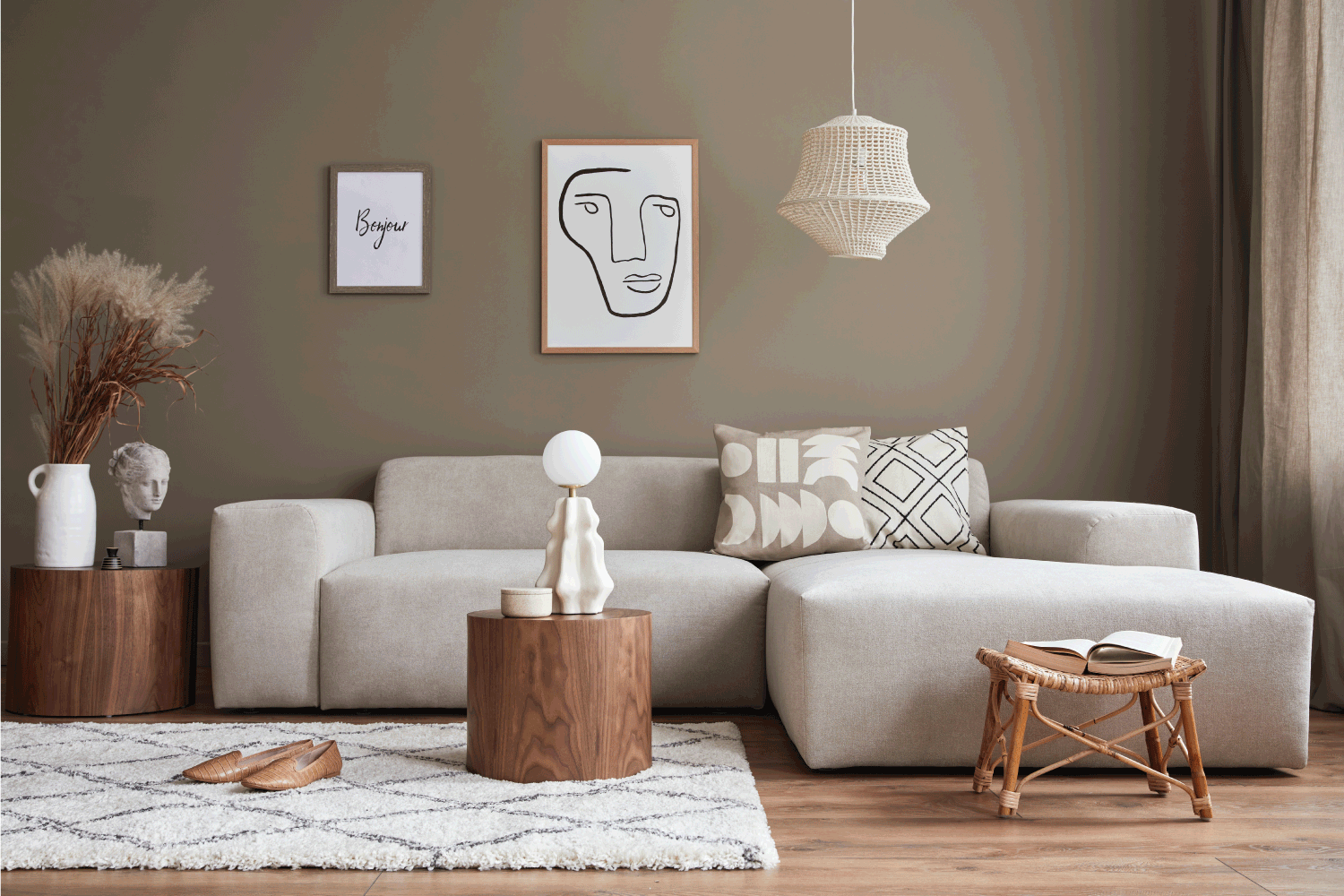soft brown and beige design of cozy living room with stylish sofa, coffee table, dried flowers in vase, mock up poster, carpet, decoration, pillows