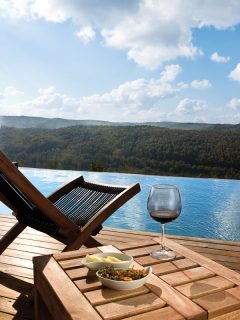 A beautiful pool deck with a scenic view of a mountain landscape, How To Protect Teak Outdoor Furniture