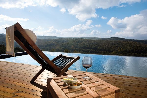 A beautiful pool deck with a scenic view of a mountain landscape, How To Protect Teak Outdoor Furniture
