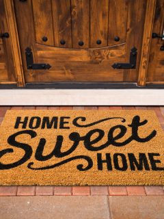 A home sweet home door mat in front of a wooden door, What Color To Paint Front Door Threshold? [5 Perfect Options]