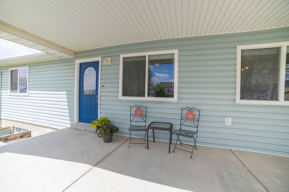 A light blue colored porch with white wooden paneled ceiling