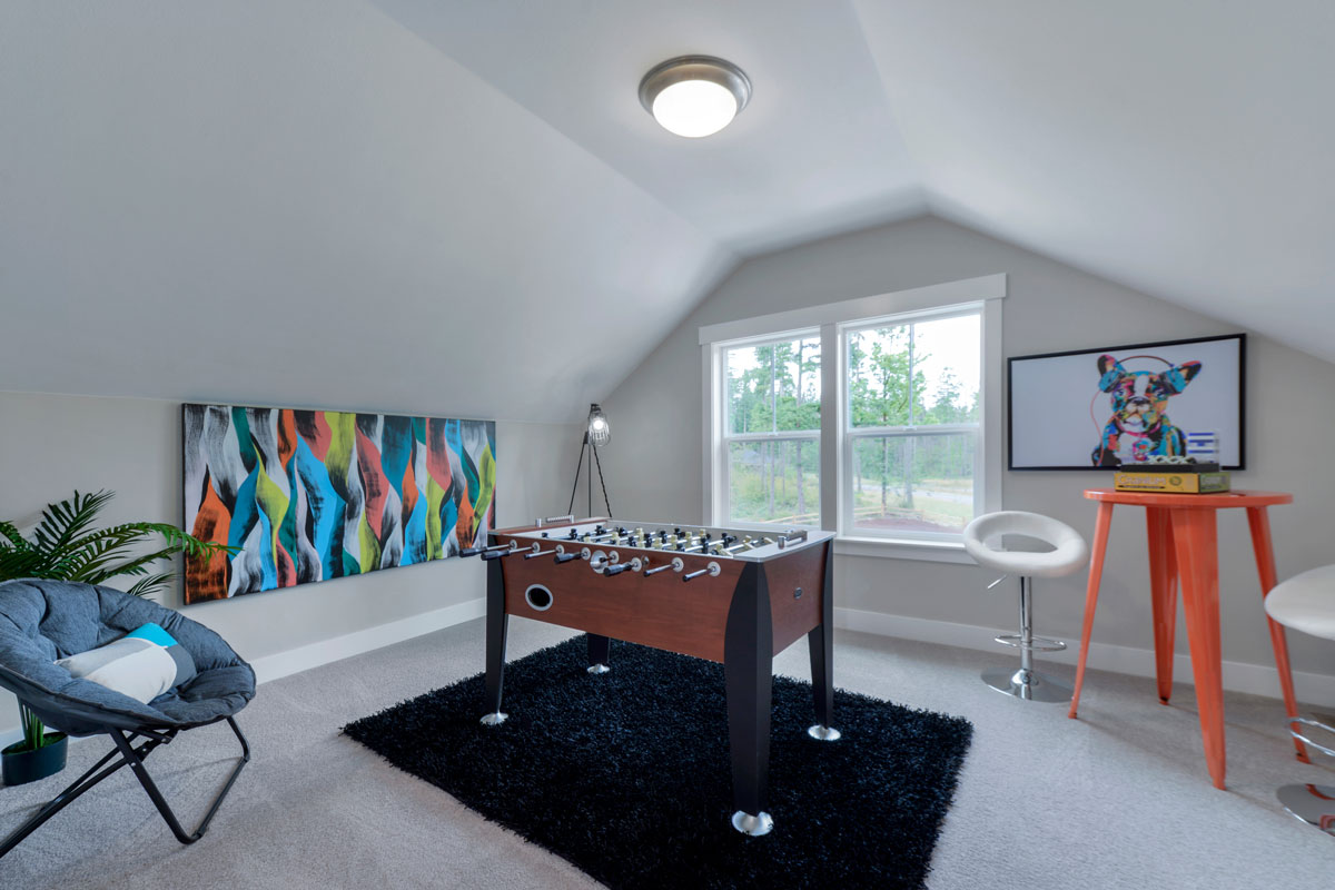 A mansard inspired entertainment room with white painted walls and a Foosball right on the center