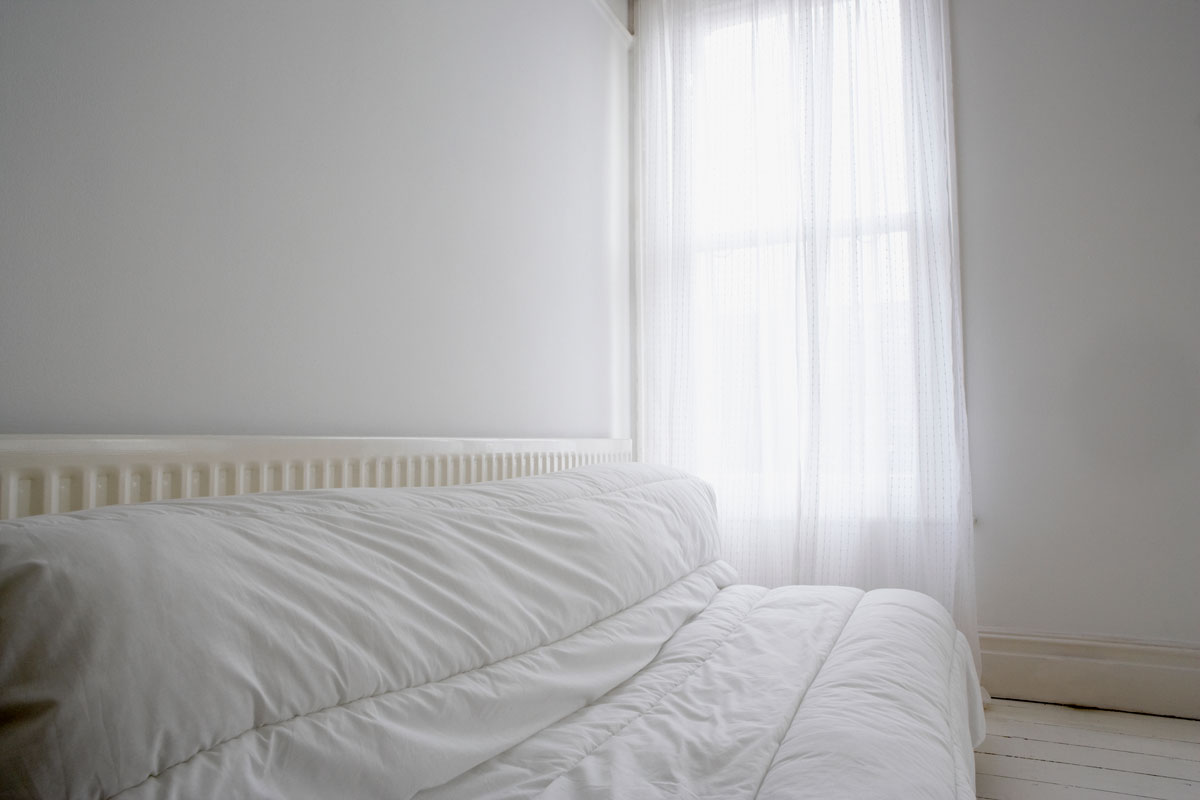 A white framed futon with white beddings