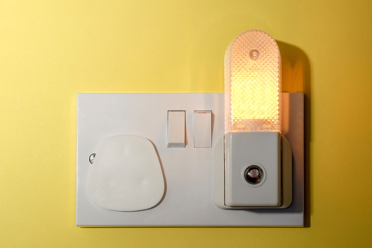 A white switch and a night light plugged on the side