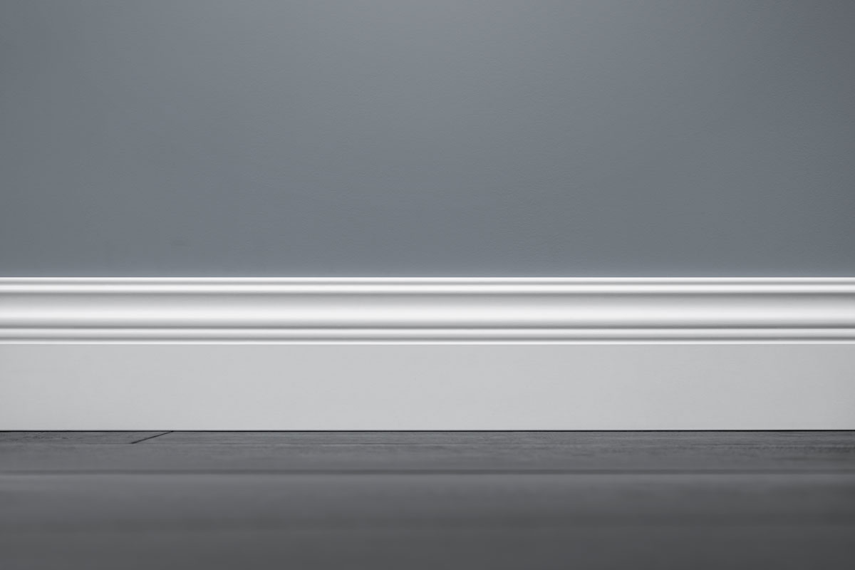 A white tall baseboard inside a gray living room