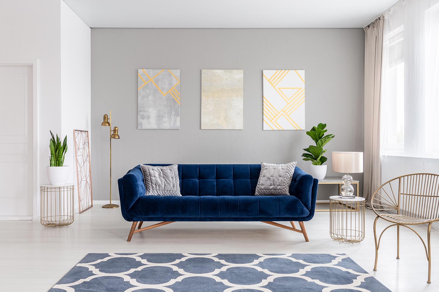 An elegant navy blue sofa in the middle of a bright living room interior