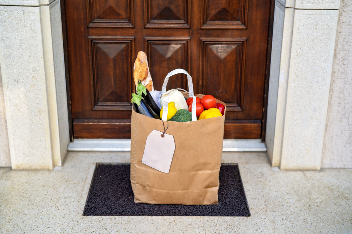 Bag of groceries placed on a black door mat