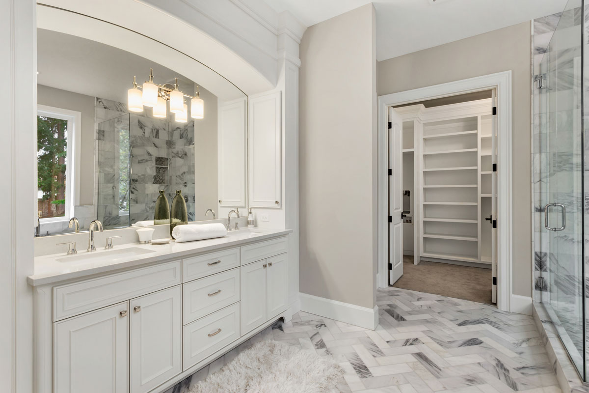 Beautiful bathroom interior in new luxury home with vanity, mirror, and cabinets