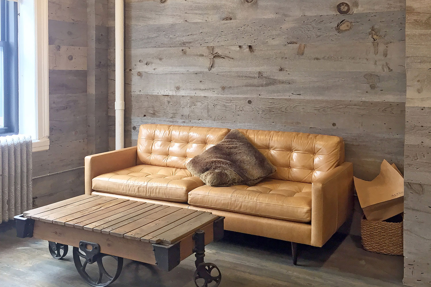 Beige leather sofa and wooden coffee table with wooden paneled wall